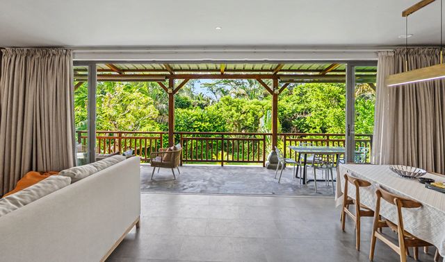 Dining table beside wide open doors to the veranda